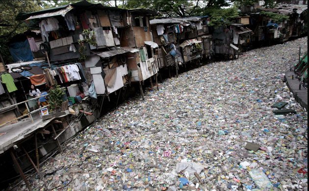 a trash-covered creek in Manila, Philippines, where slums often adjoin rubbish dumps. The country's poorest sift through the garbage to find discarded objects they can sell on or re-use, or even scraps of food to eat.